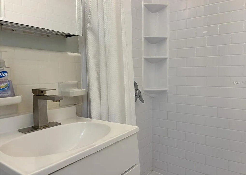 Bathroom shower and sink inside Pelican Gardens Unit 8